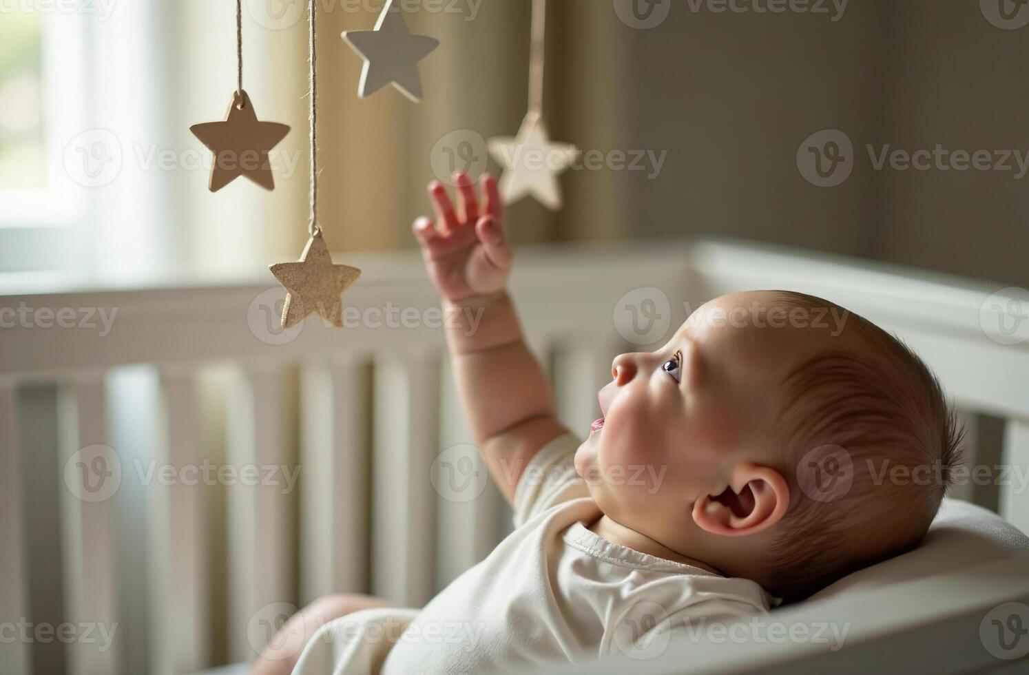 Mobile over crib, newborn touching toys with hand, children cool room photo