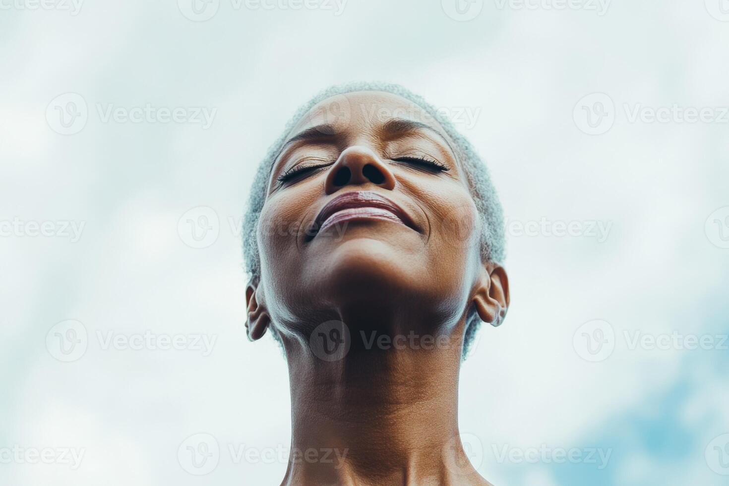 A woman with a smile looking up at the sky photo