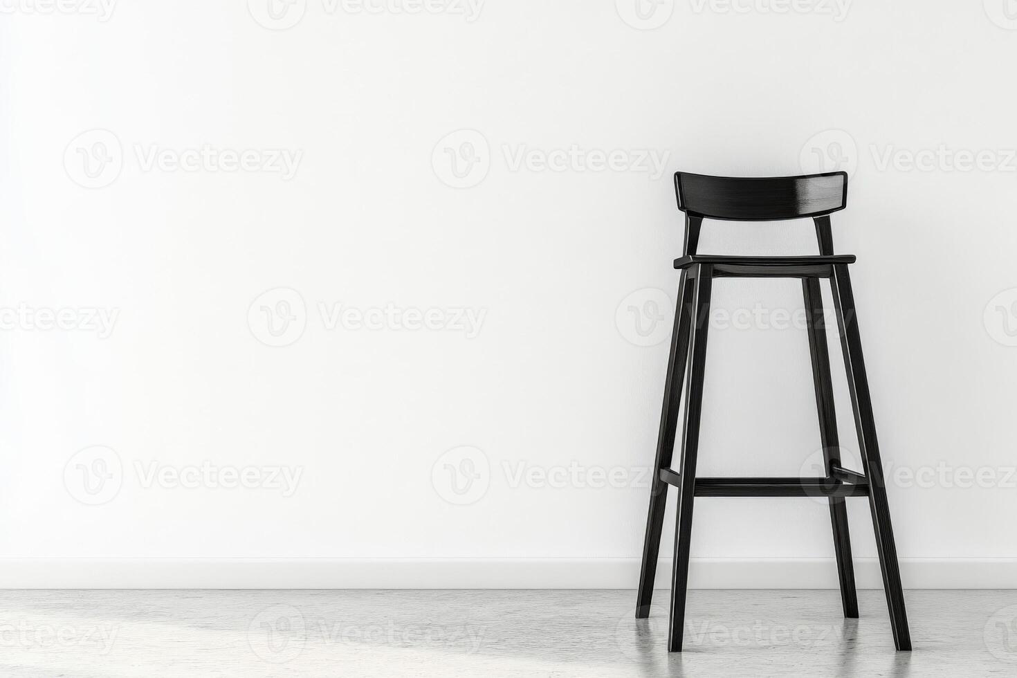 A black stool against a white wall photo