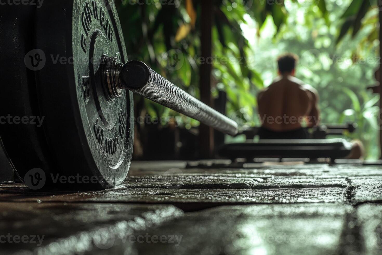 A man is sitting on a bench with a barbell photo