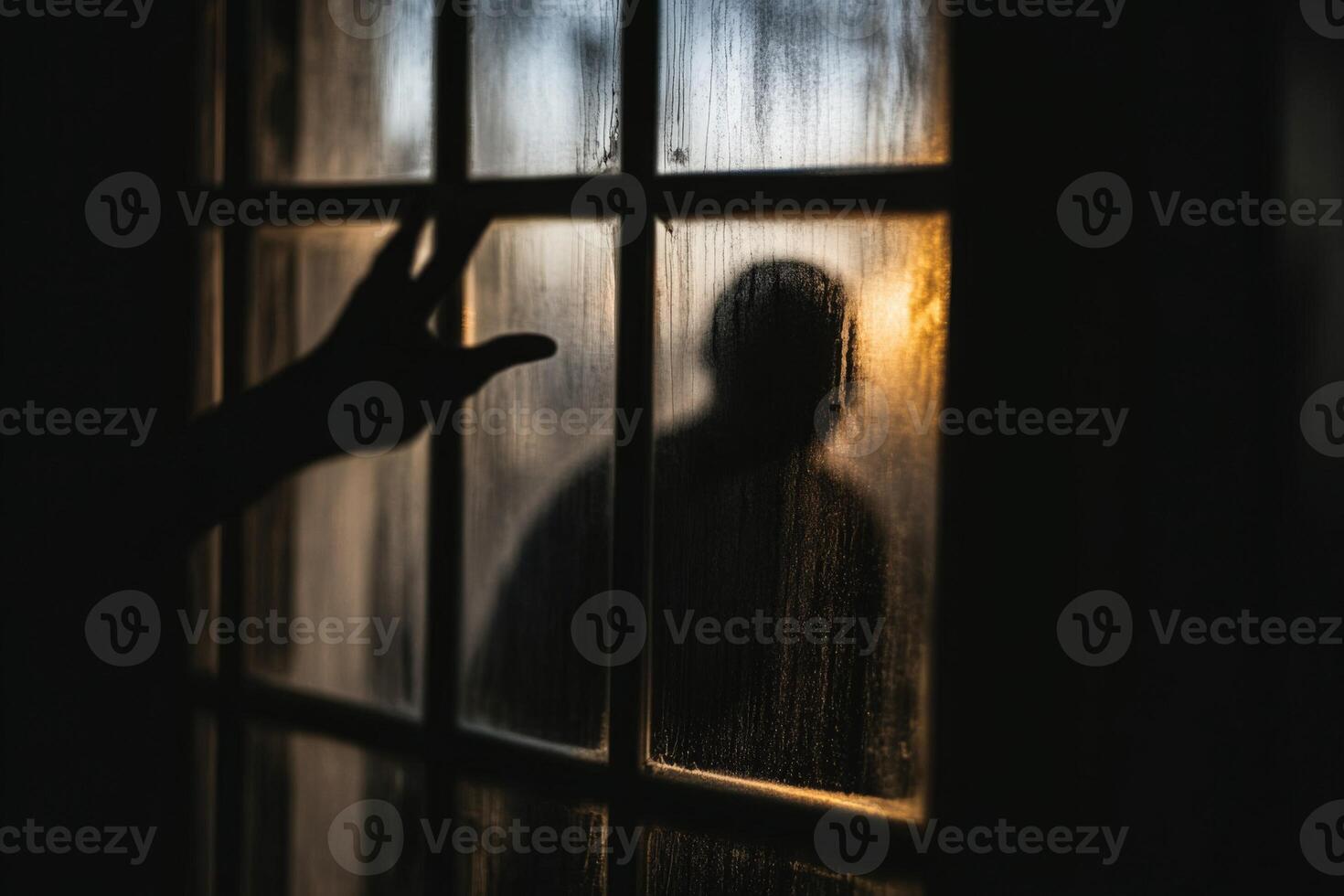 A person is standing in front of a window with a hand reaching out photo