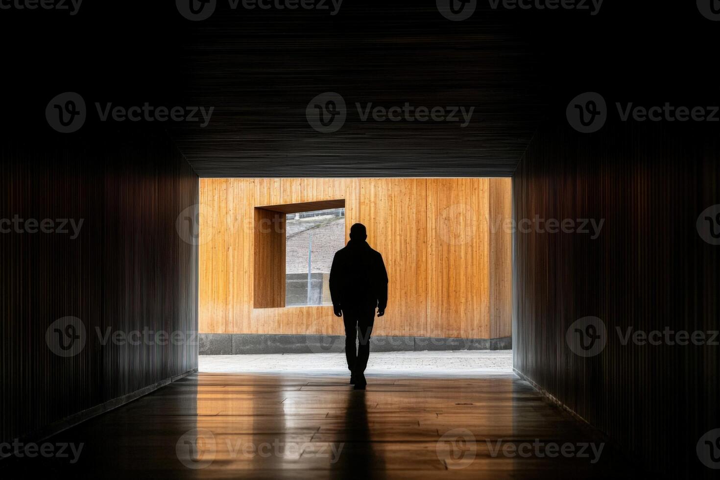 A man walking through a dark tunnel photo