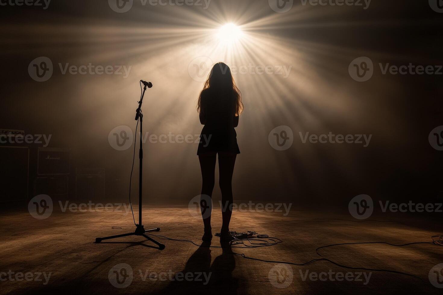 A woman standing in front of a microphone in a dark room photo