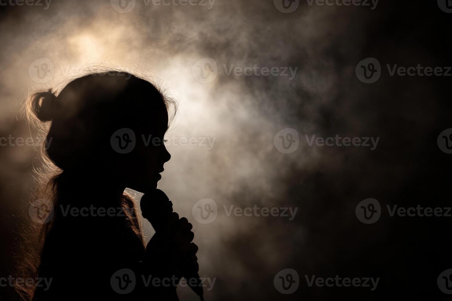 Silhouette of a girl singing in the dark photo