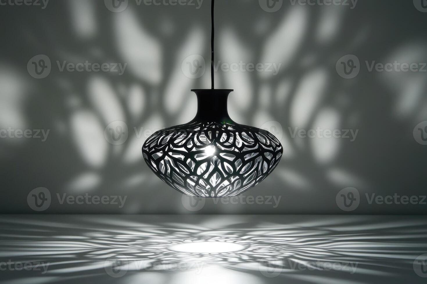Black Hanging Lamp with Intricate Cutouts Casting Shadows photo