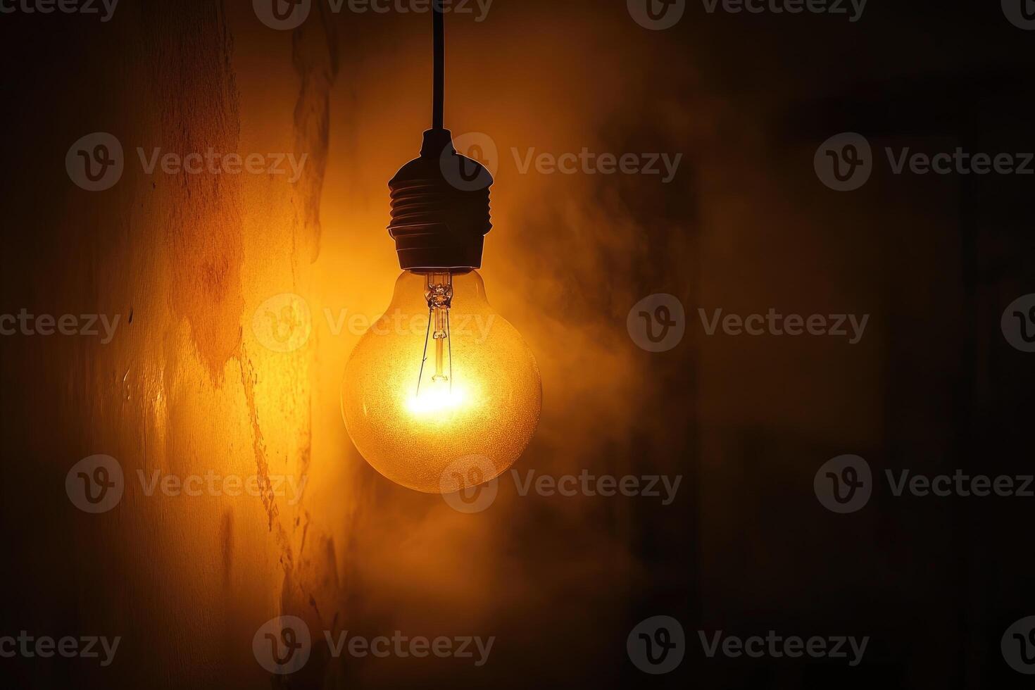 Glowing Light Bulb Hanging in a Dark Room photo