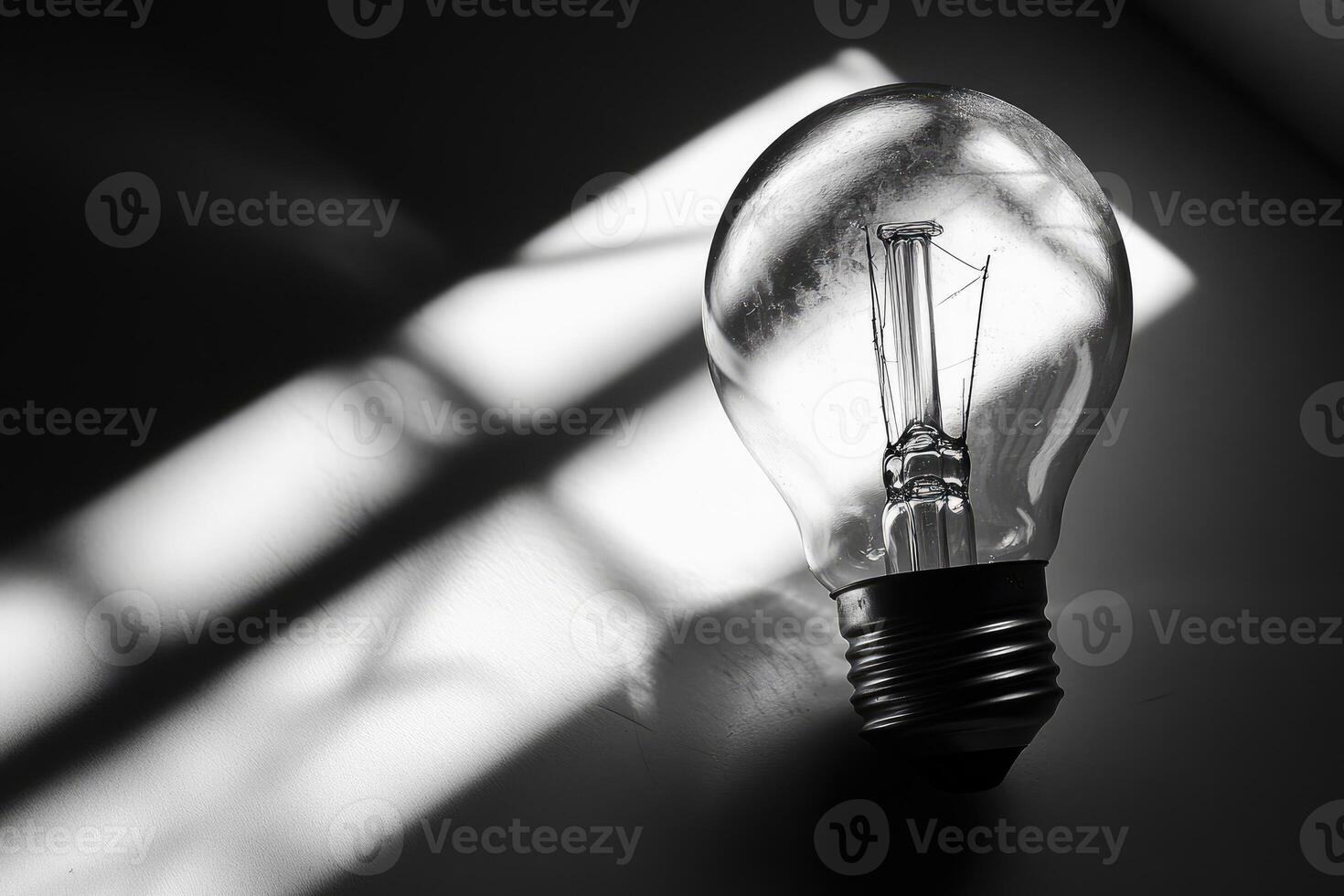 A Light Bulb in a Beam of Light with a Shadow of a Window on a Wall photo