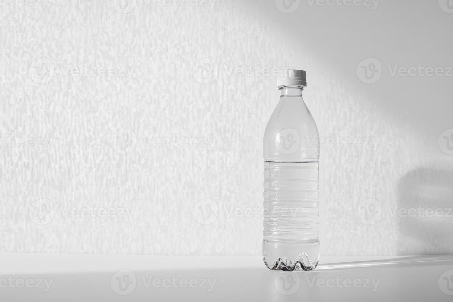 A Single Plastic Water Bottle on a White Tabletop with a White Textured Background photo