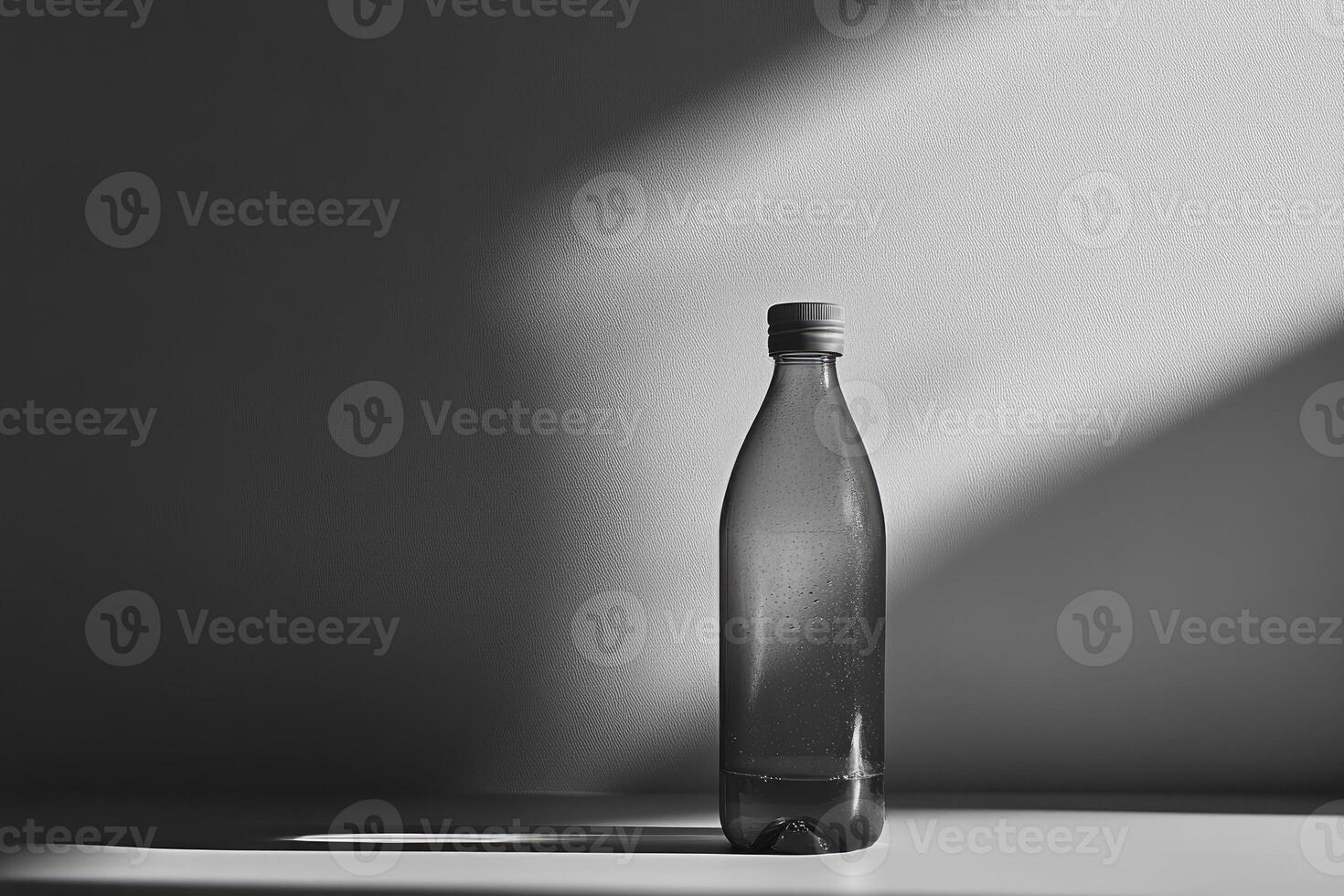 A Single Water Bottle Against a White Wall with Shadows photo