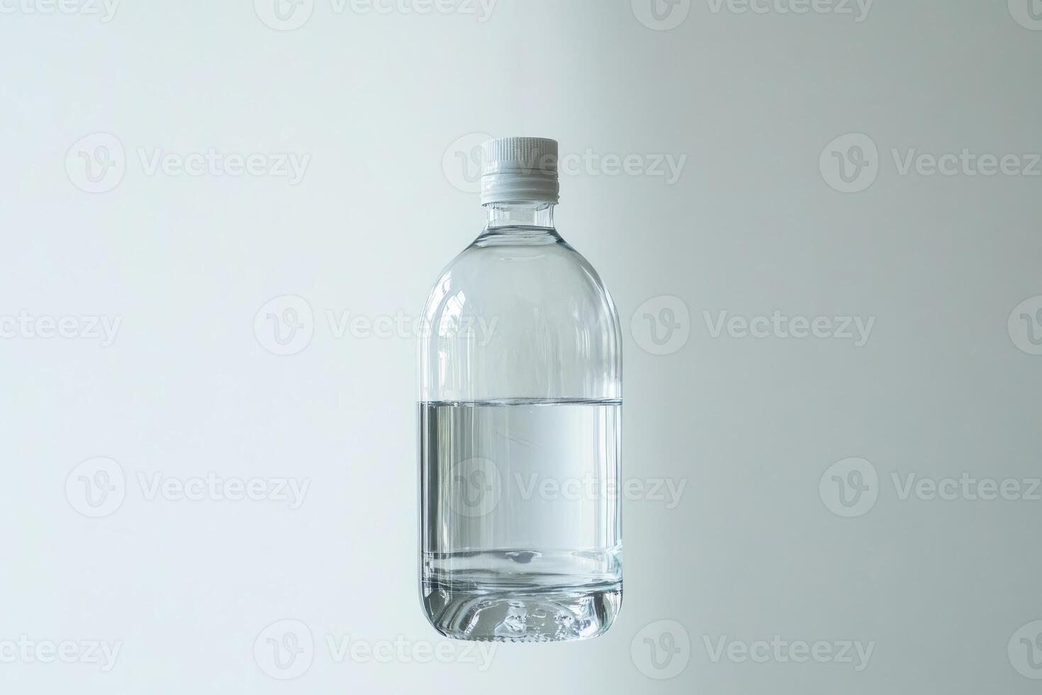 A Clear Plastic Bottle with White Cap Partially Filled with Water photo