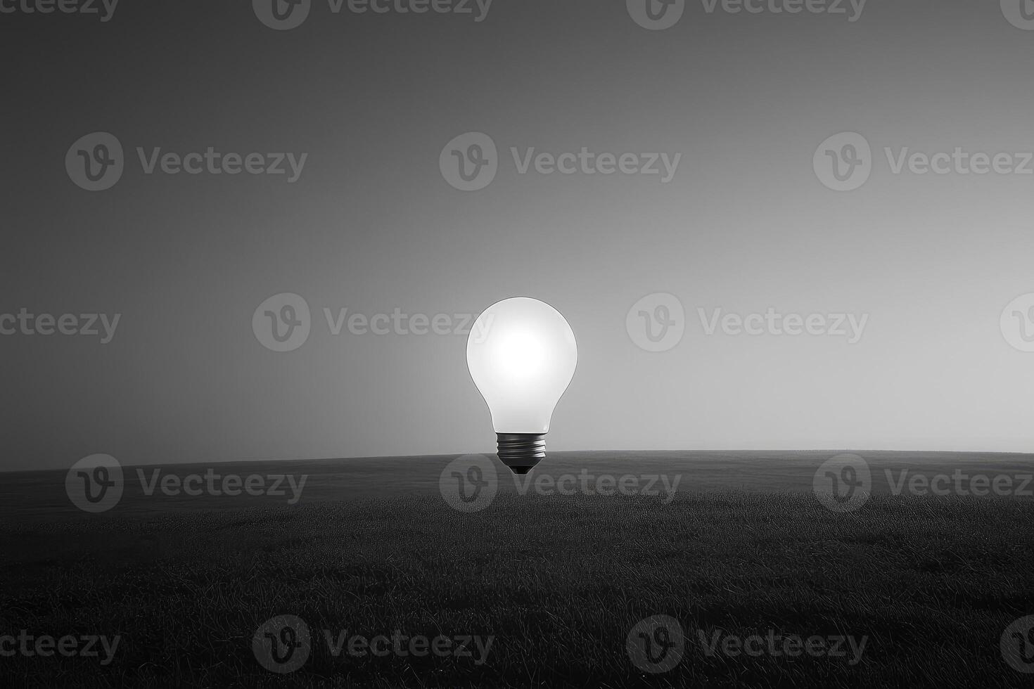 A Single Illuminated Lightbulb Standing in a Field of Grass photo
