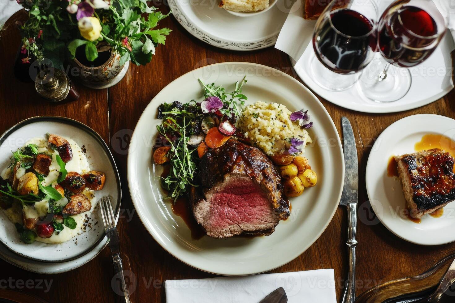 A table with a steak, potatoes, and wine photo