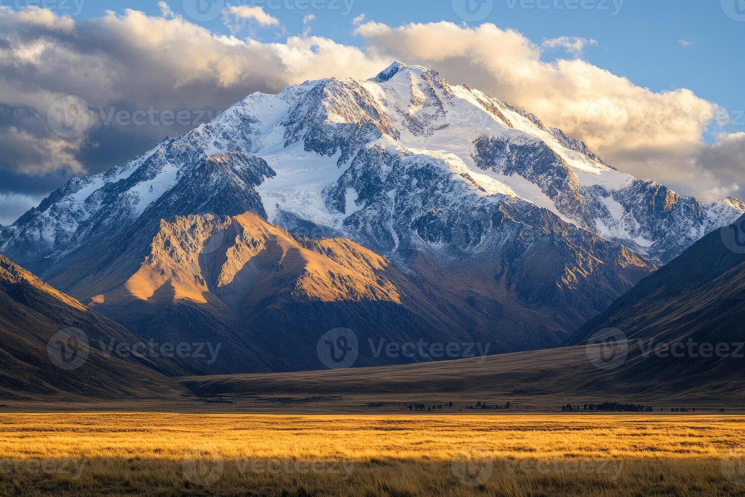 Majestic snow capped mountain range at sunset over golden grasslands photo