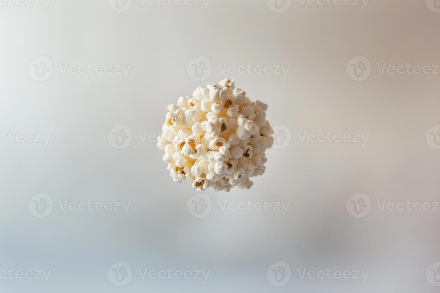 A spherical cluster of popcorn floats against a plain background photo