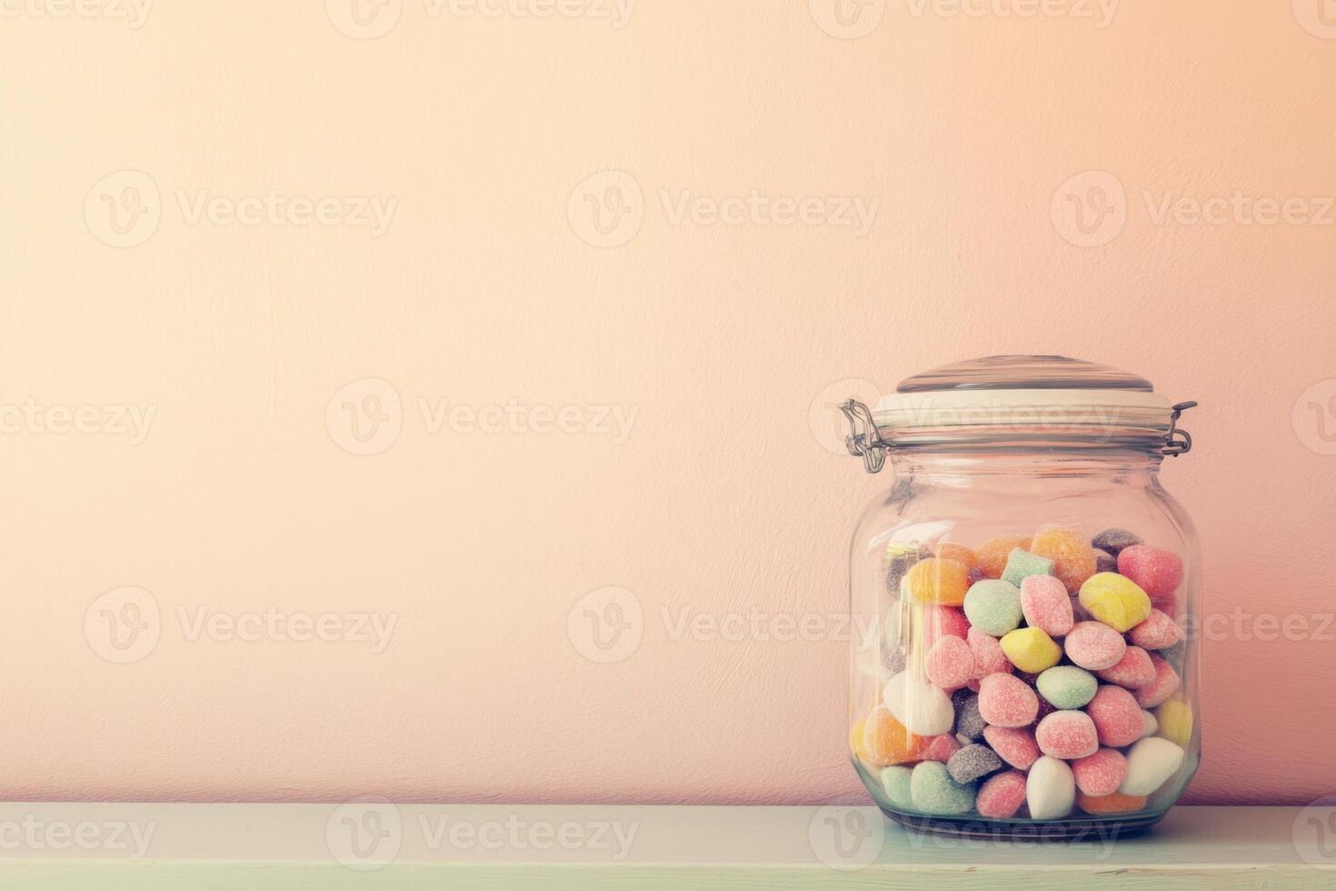 Colorful Candies in Glass Jar Against Pink Wall photo