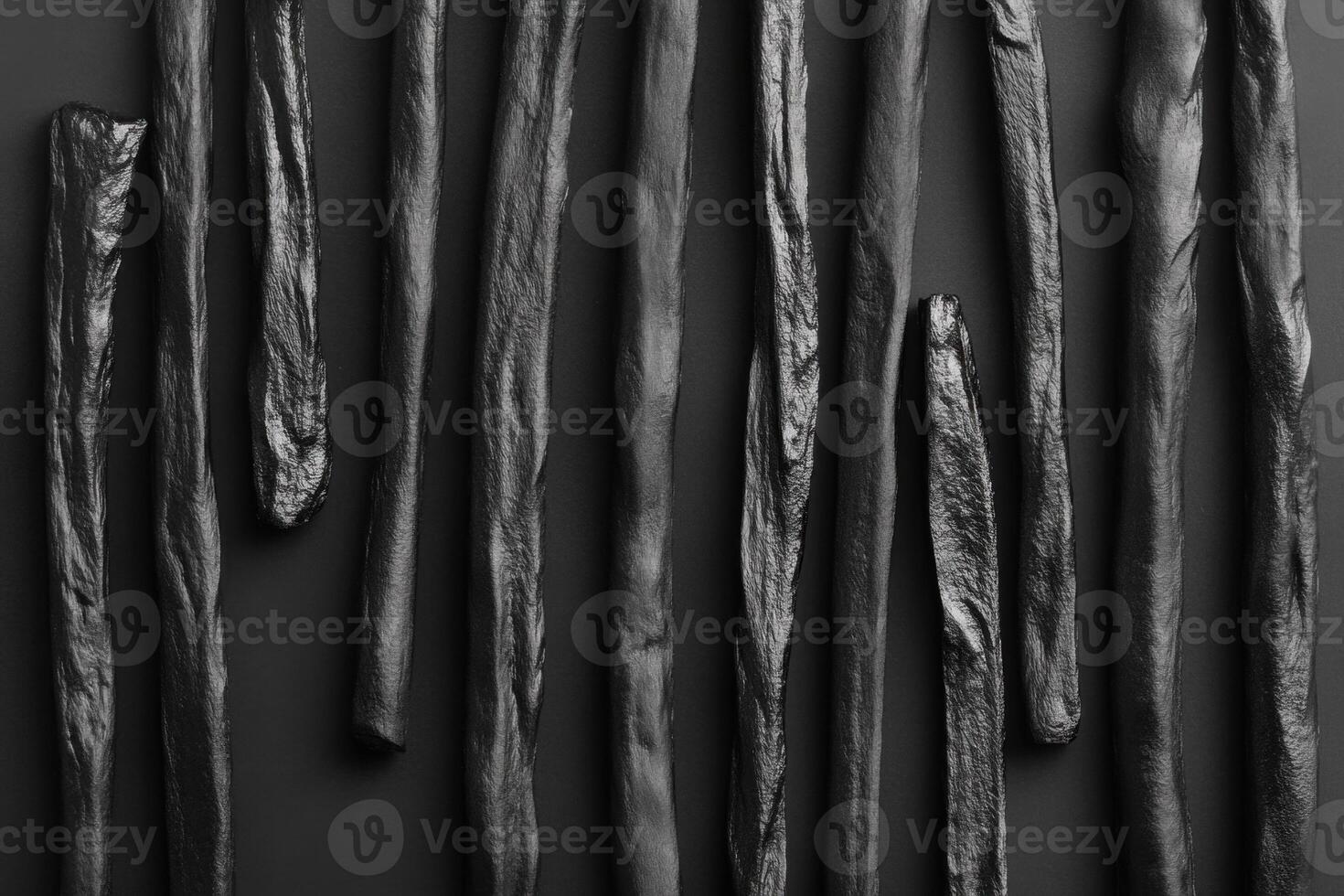 Black textured sticks arranged in a vertical pattern photo