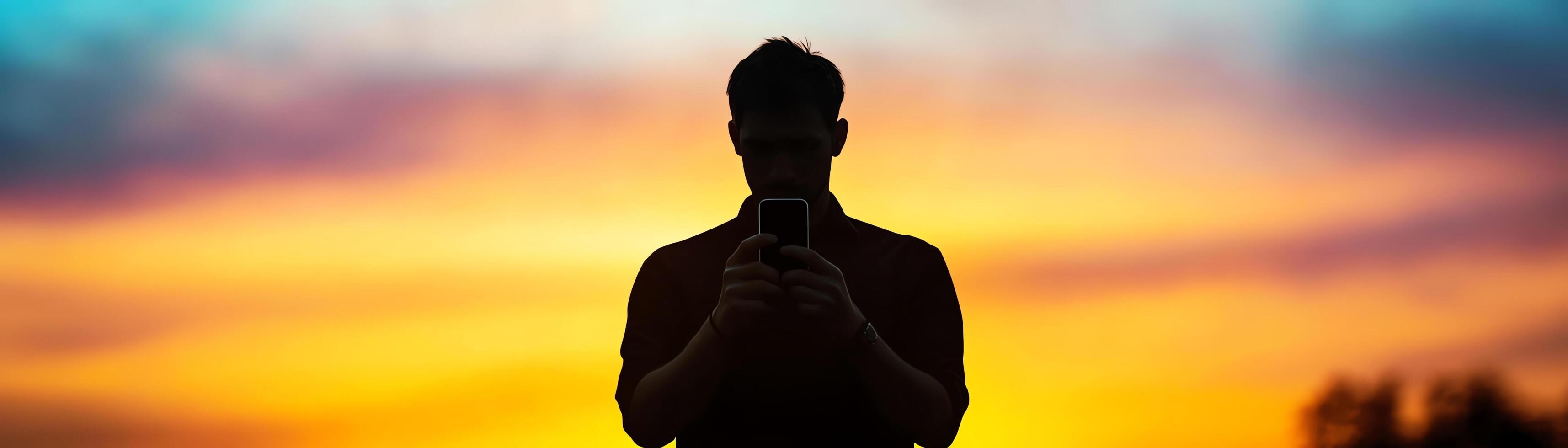 Silhouette of a person using smartphone at sunset. photo