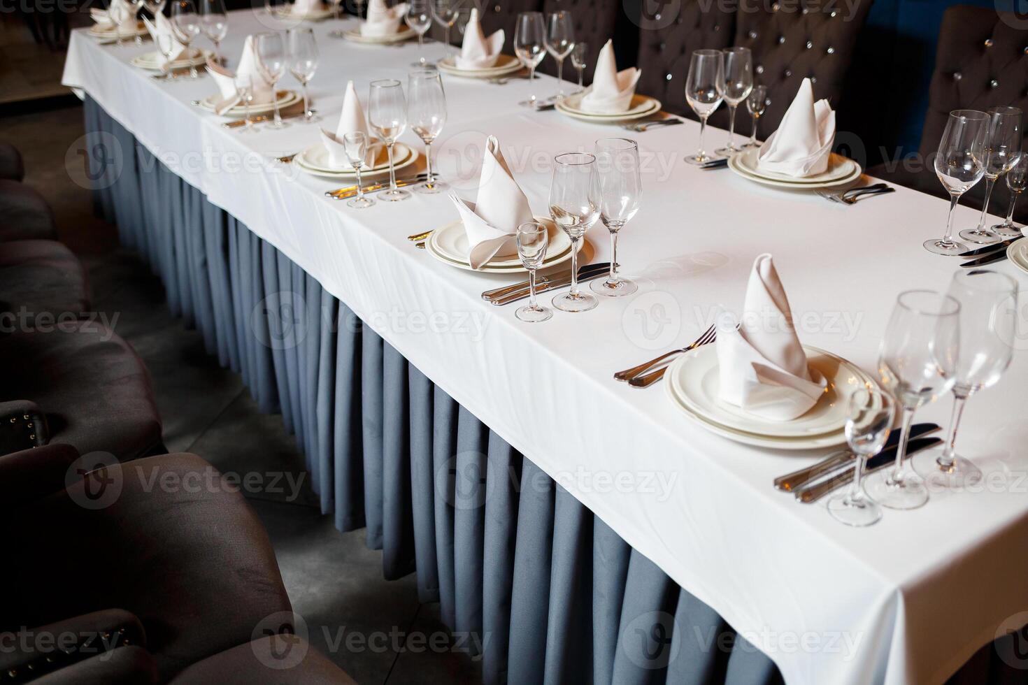 Serving a festive table in a restaurant. Preparation of a banquet for a holiday. Expensive decoration materials. Dishes for food and drinks photo