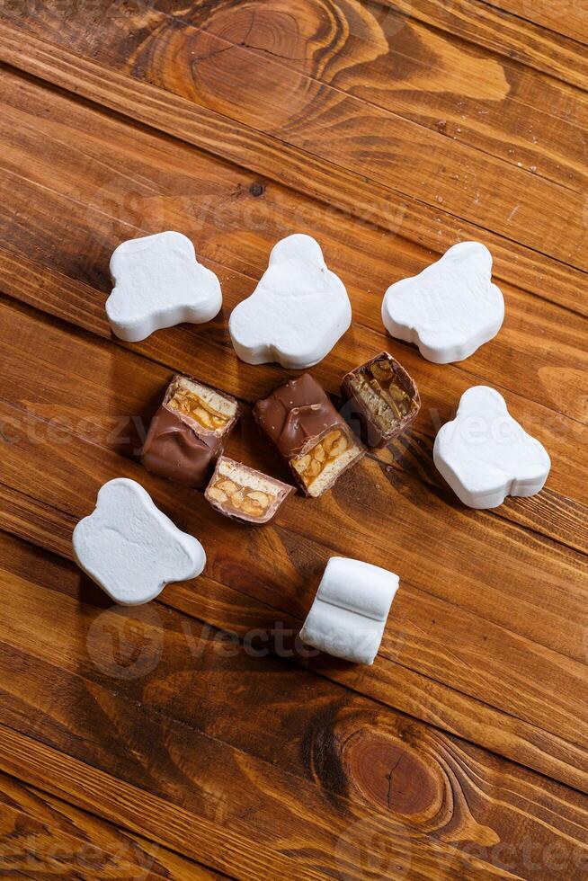 chocolate with nuts on a wooden board with marshmallows photo