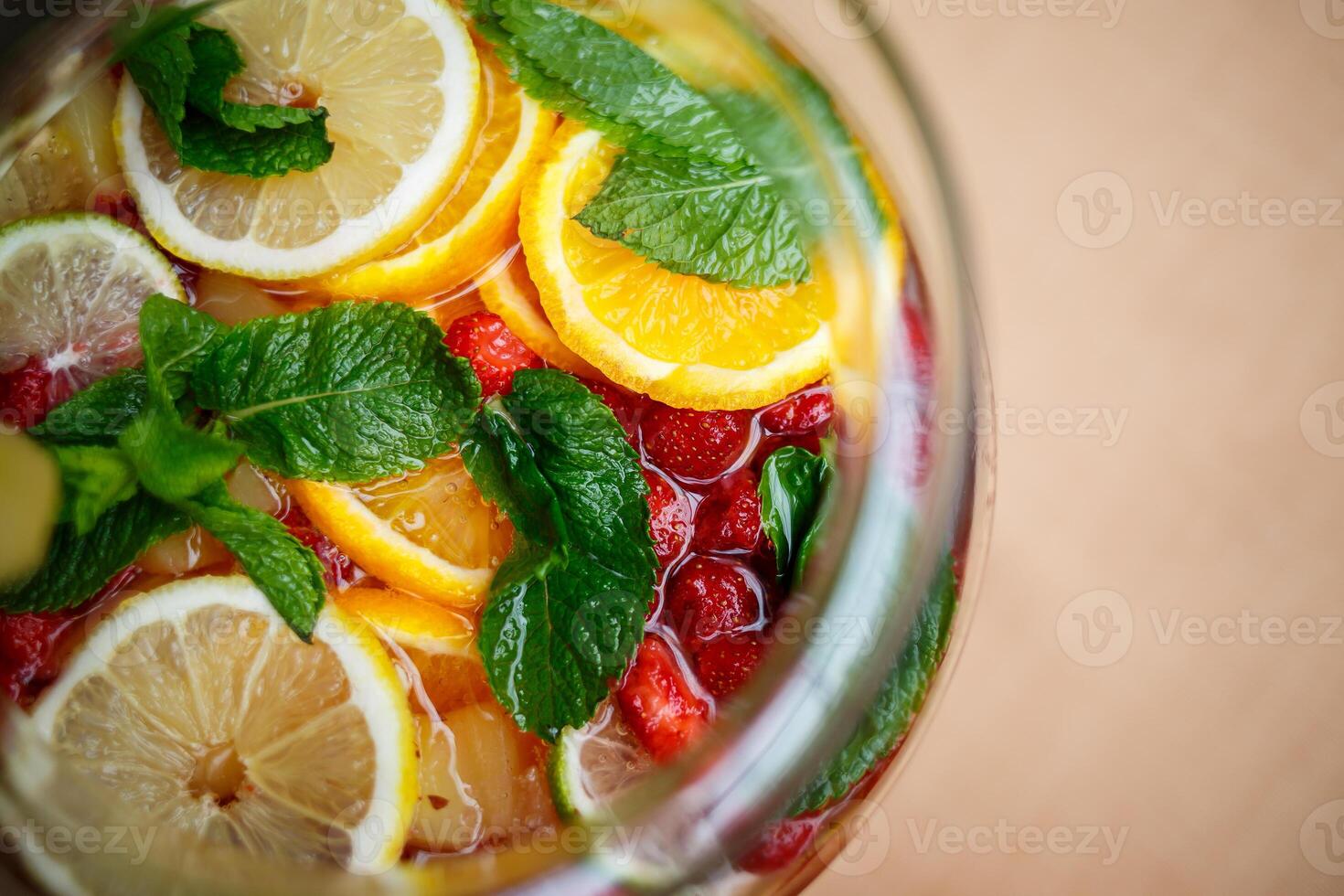Refreshing lemonade with fresh fruit orange lemon cherry and mint leaves. Delicious non-alcoholic fruit cocktail in a jug photo