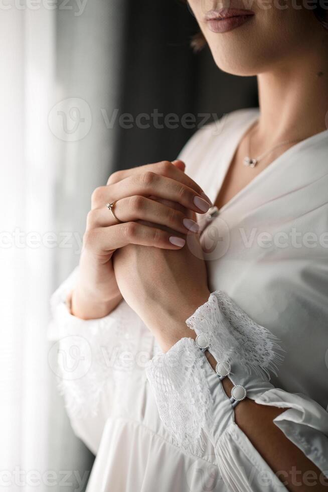 Gentle female hands of the bride with a gold wedding ring on the ring finger photo