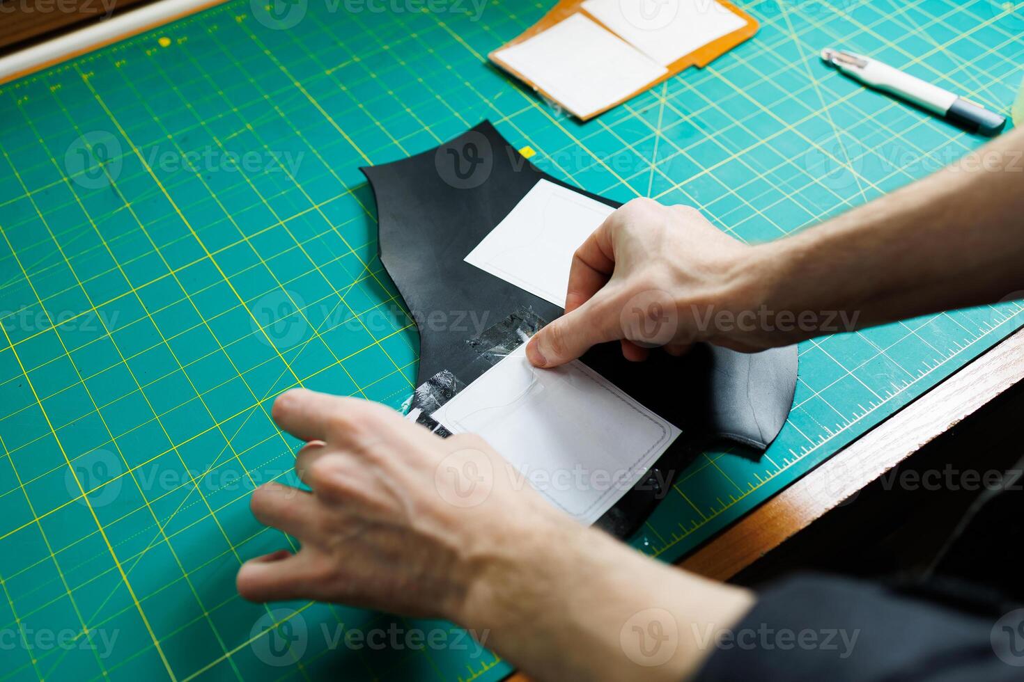 Hands of a professional craftsman make a leather wallet new, clean genuine leather wallet, close-up cropped shot. photo