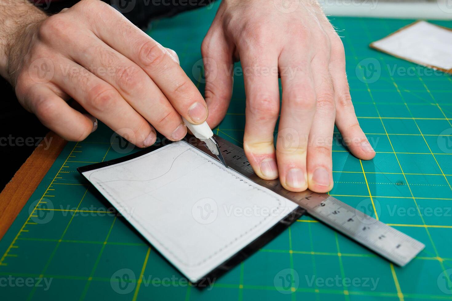 The hands of the master sew handmade leather products. Men's hands connect the parts, creating quality leather accessories. Working process in a leather workshop photo