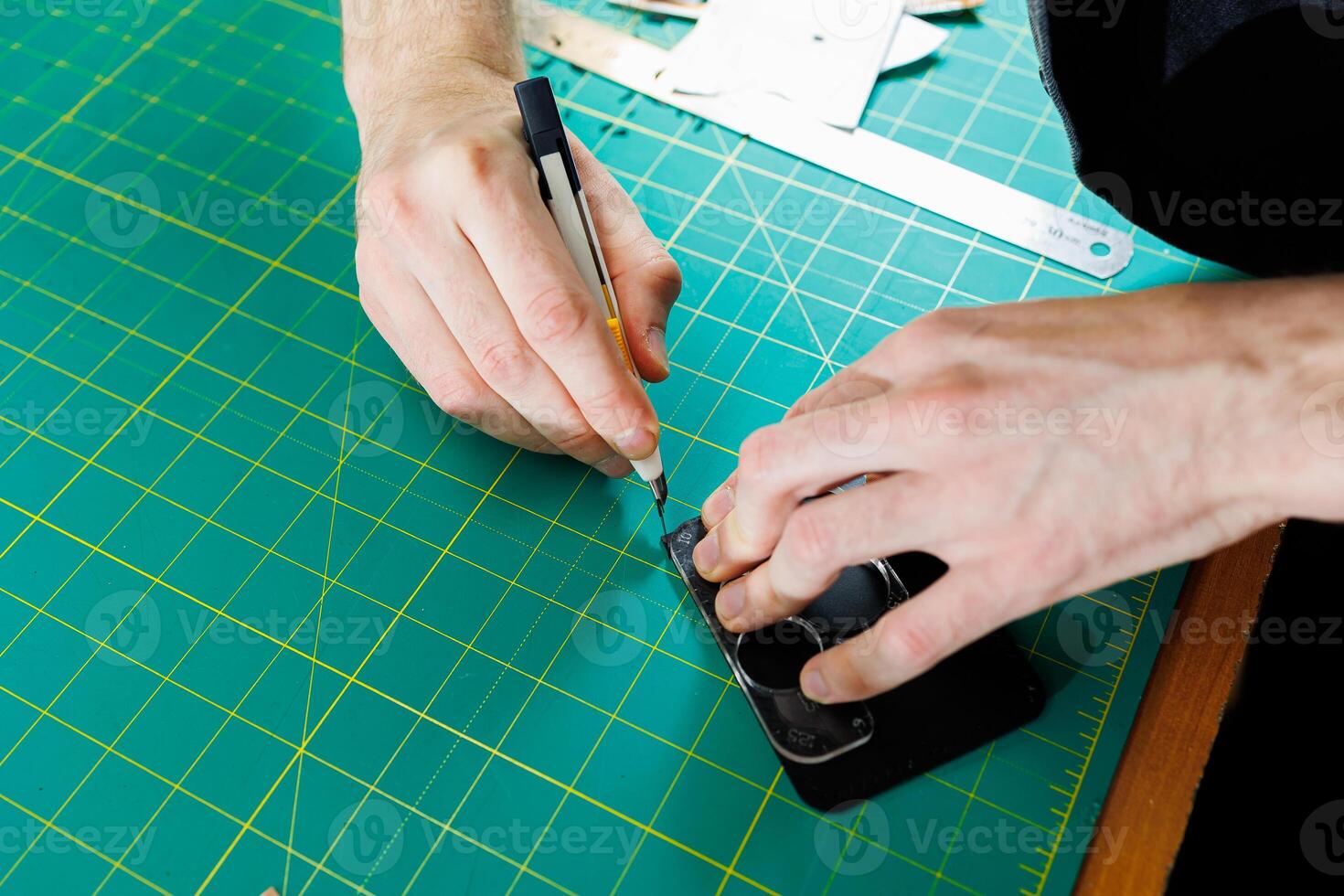 Hands of a professional craftsman make a leather wallet new, clean genuine leather wallet, close-up cropped shot. photo