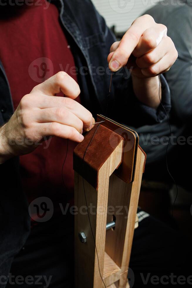 Close-up of male hands working with natural leather. Handmade products made of genuine leather. photo