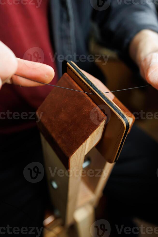 Close-up of male hands working with natural leather. Handmade products made of genuine leather. photo