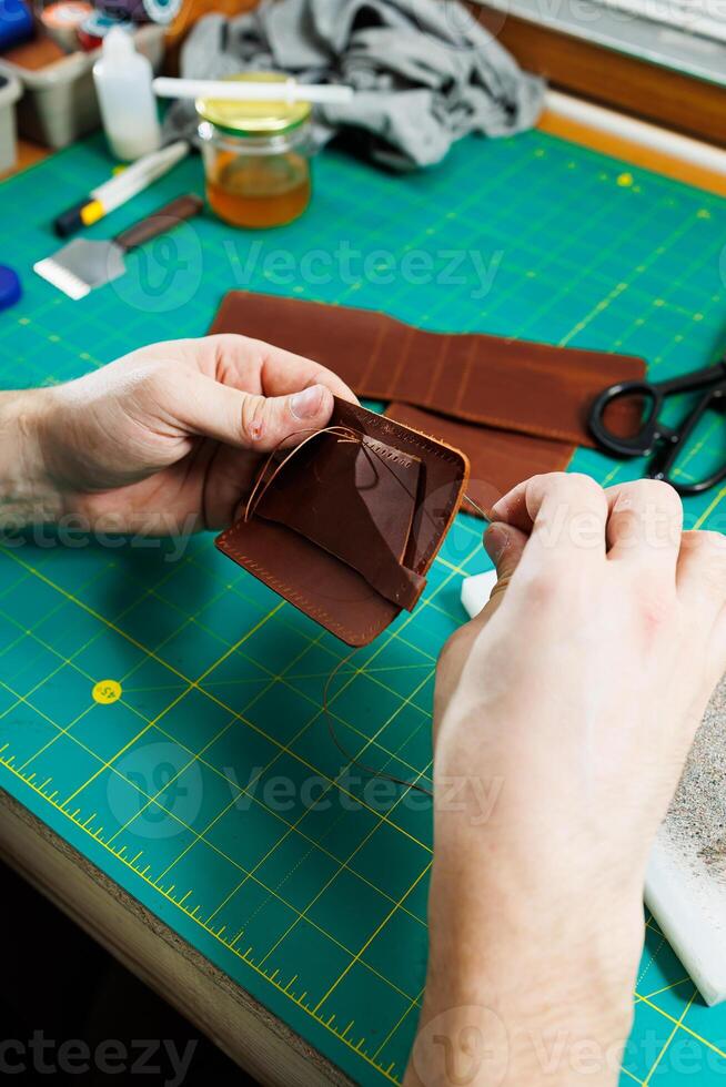 Close-up of male hands working with natural leather. Handmade products made of genuine leather. photo