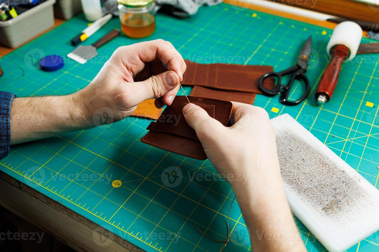 Close-up of male hands working with natural leather. Handmade products made of genuine leather. photo