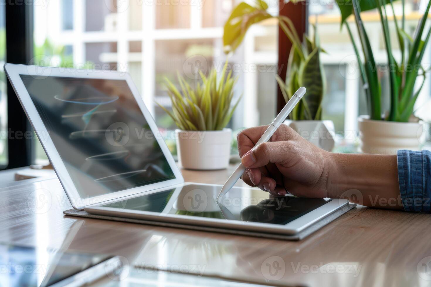 A man using a pen to write on a laptop photo