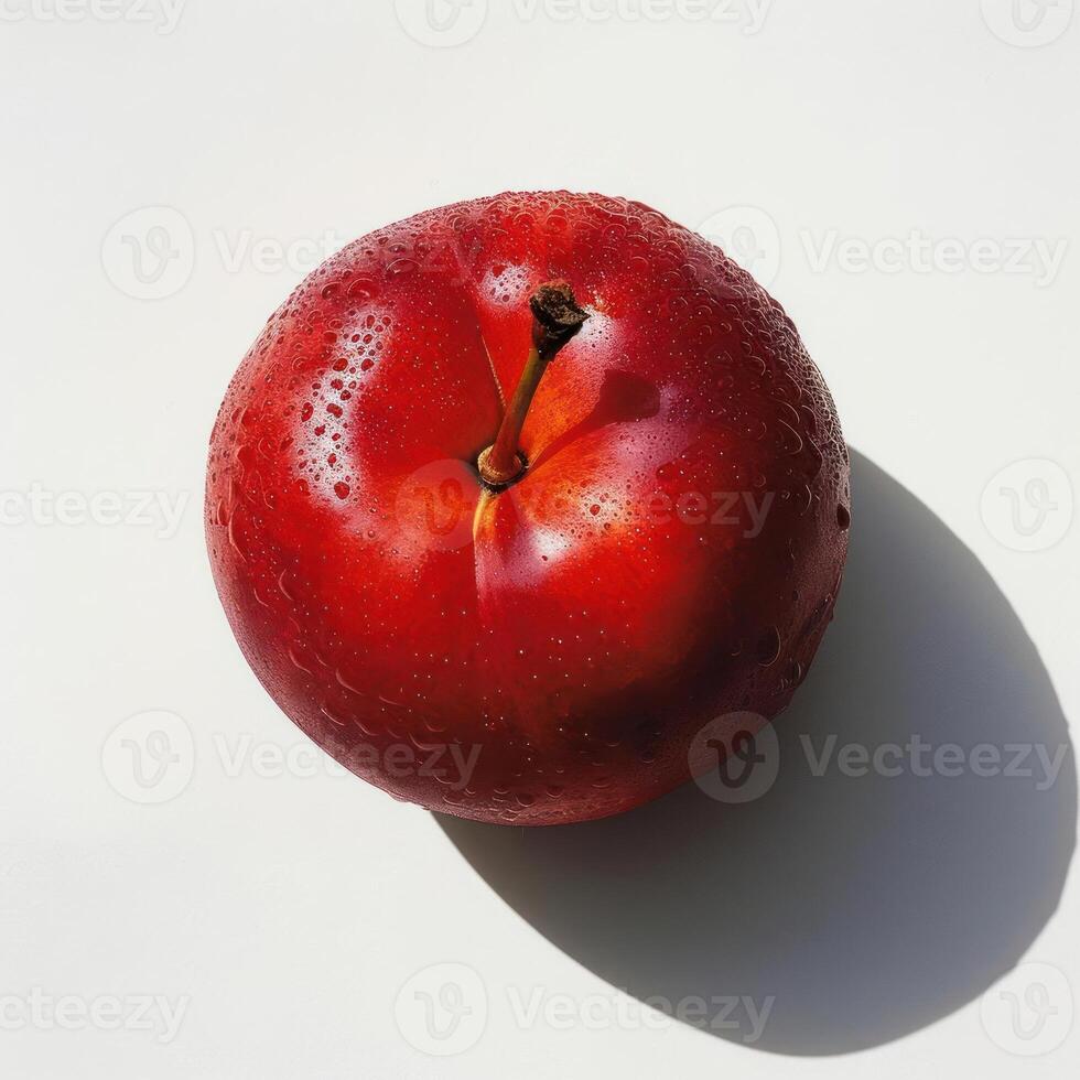 A red apple with a glossy surface and droplets of moisture, resting on white background. photo