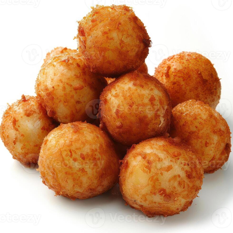 A stack of golden, fried cheese balls with crisp outer coatings, resting on a white surface. photo