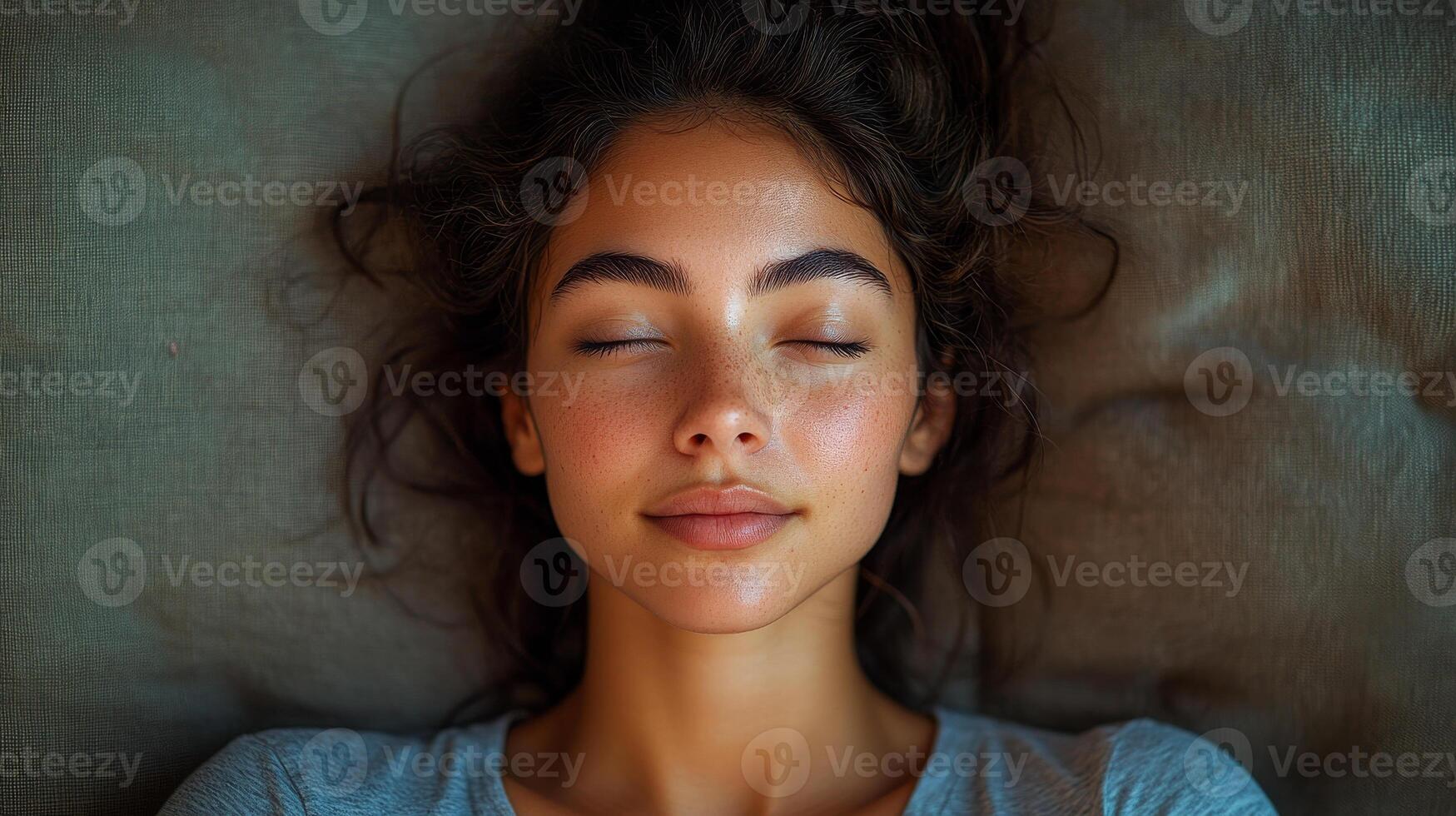 A woman with long hair is sleeping on a couch. She has a beautiful face with a nice smile photo