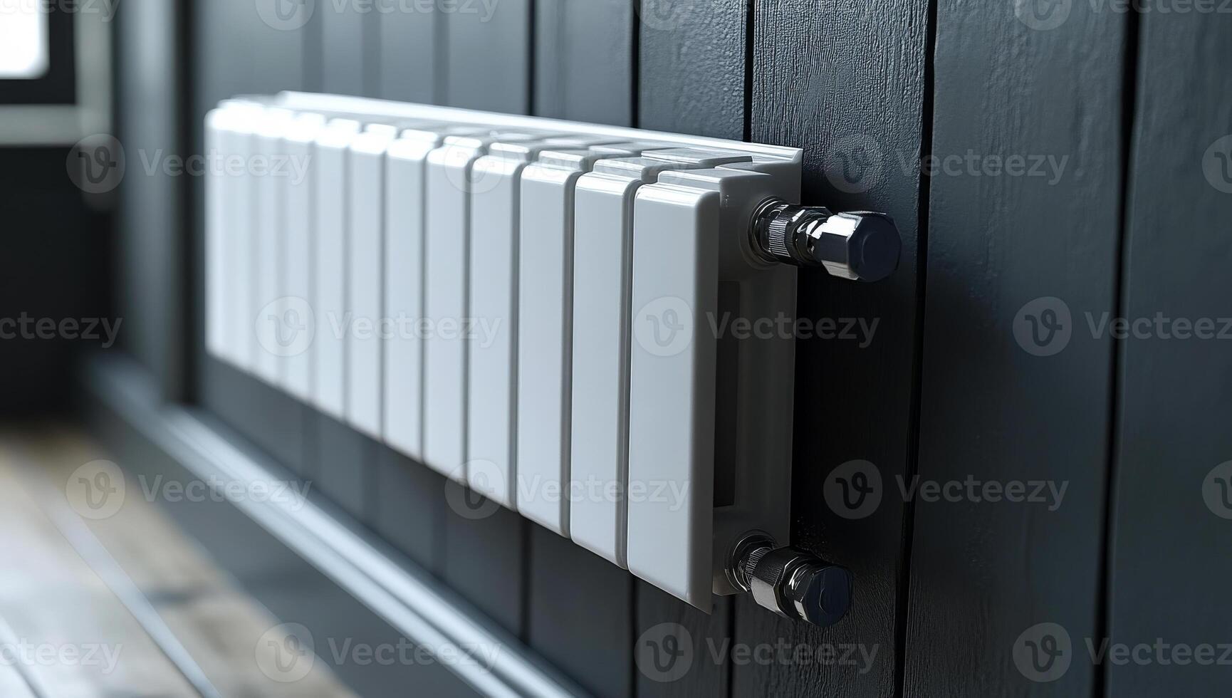 A white radiator is mounted on a wall. The radiator is white and has a black handle photo