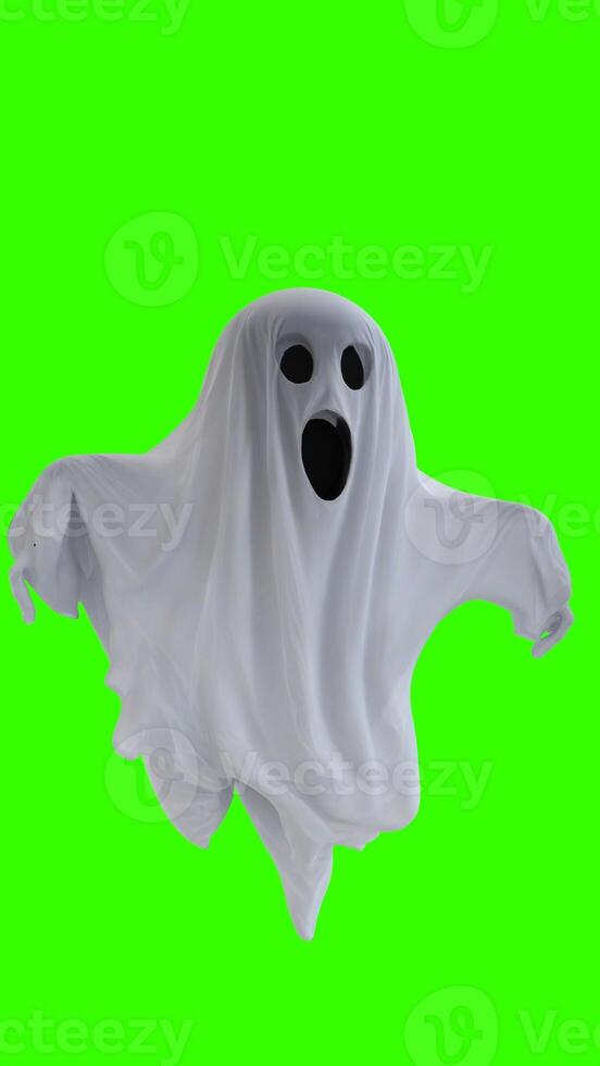 ghost in a white sheet with green background photo