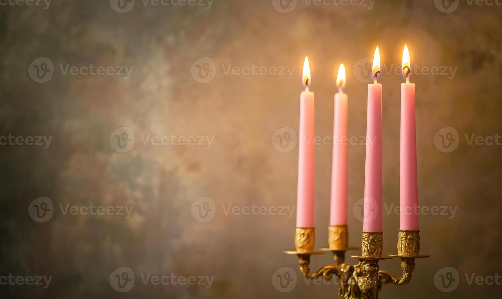 Four pink candles are lit on a gold candlestick photo