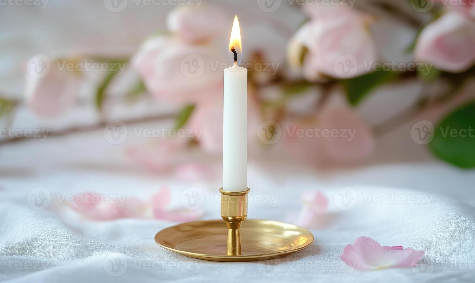 A candle is lit in a gold holder photo