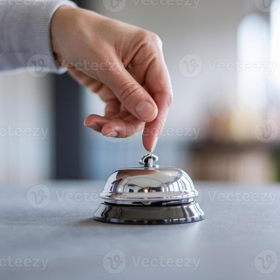 Hand about to ring shiny metallic bell, with a calm, focused indoor background For Social Media Post Size photo