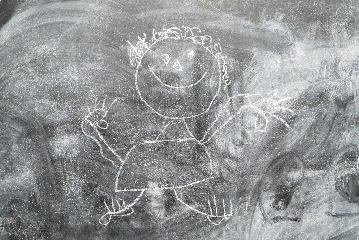 Chalk drawing of a cheerful stick figure on a blackboard photo