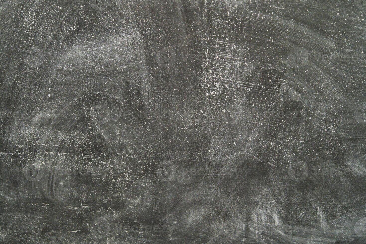 Textured black surface with scratches and chalk marks in a classroom photo
