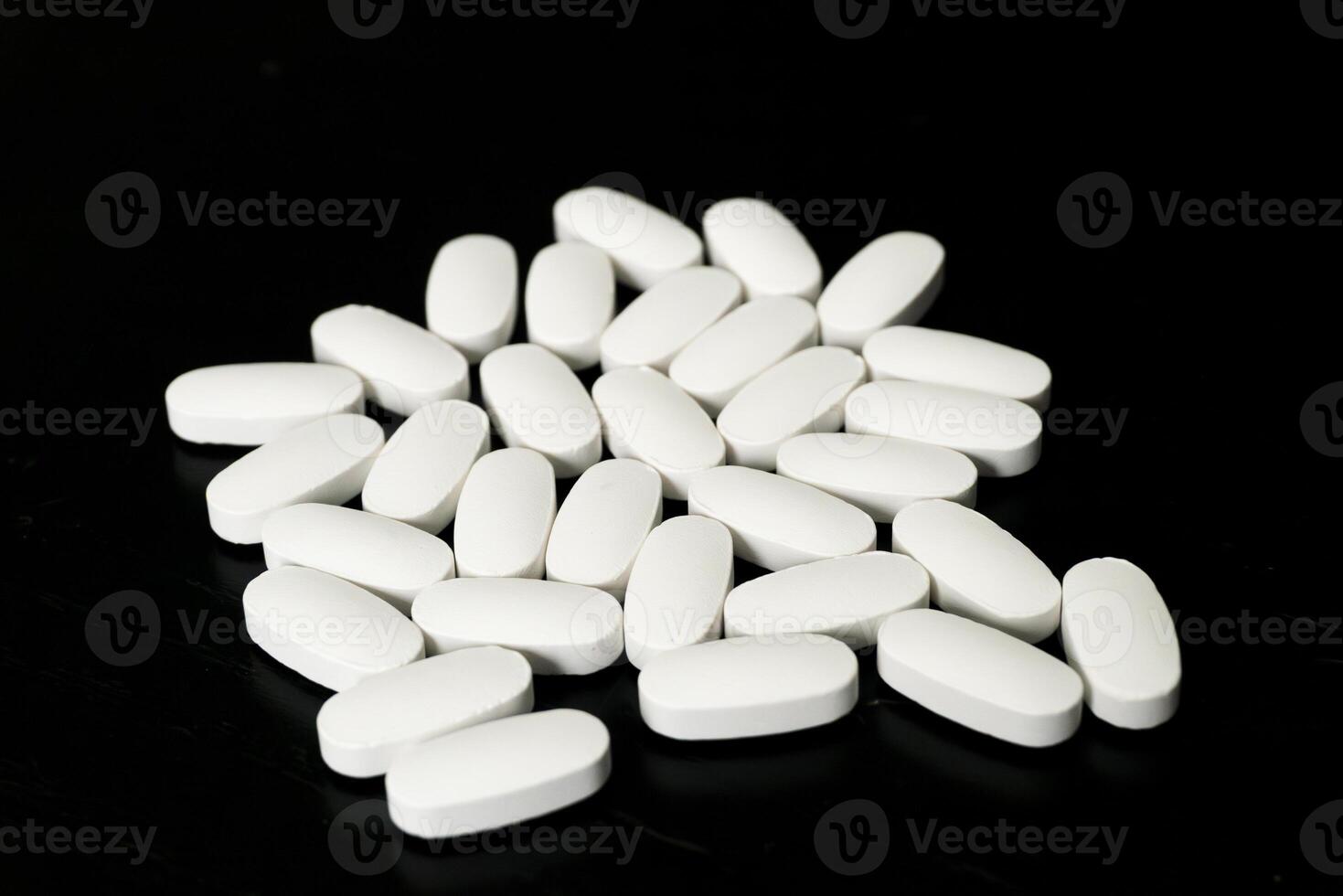 White tablets arranged on a black surface for identification purposes photo