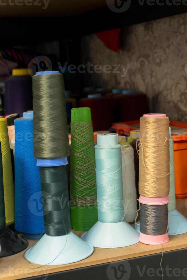 Colorful spools of thread arranged on a shelf in a sewing studio photo