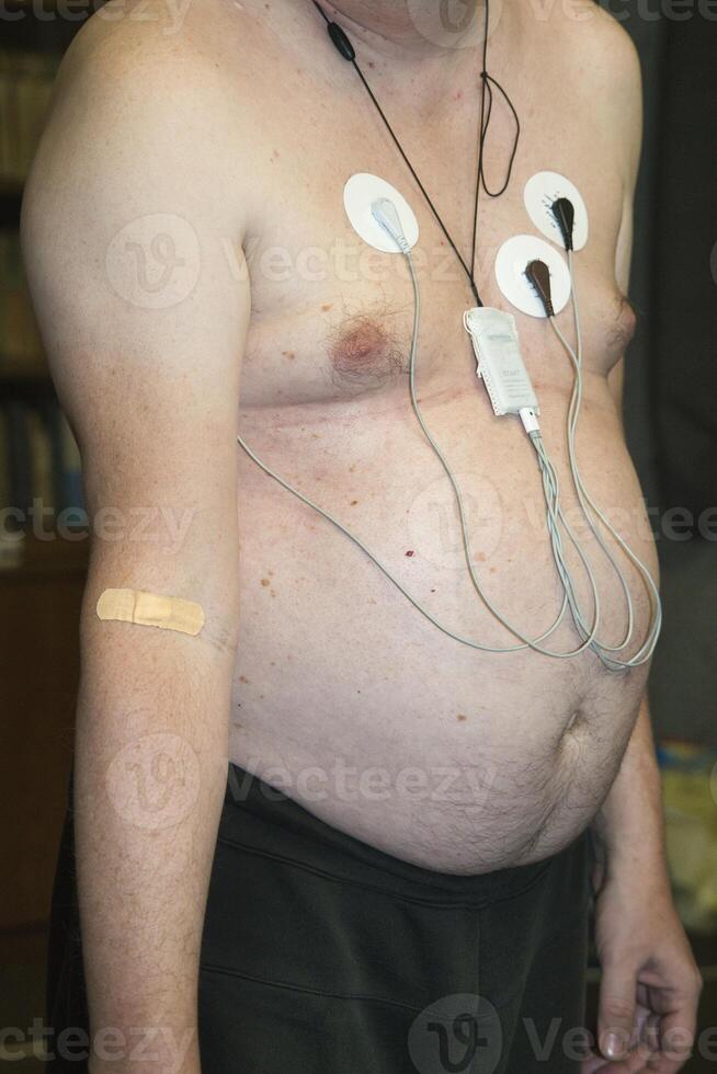 Man undergoing electrocardiogram monitoring in a medical setting photo