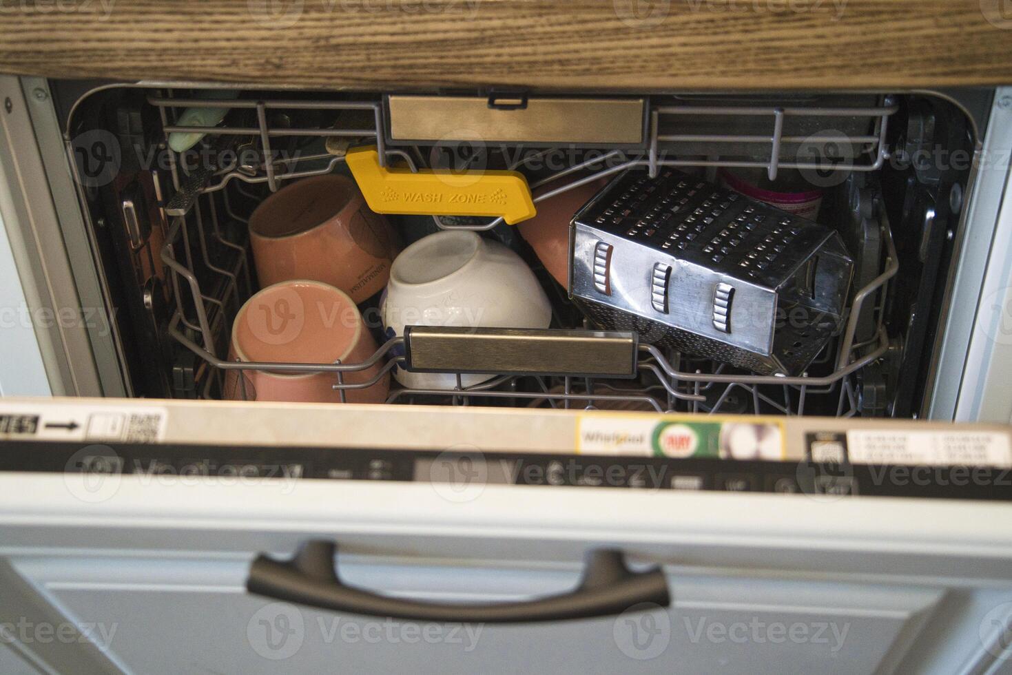 Dishwasher loaded with utensils and cookware for cleaning photo