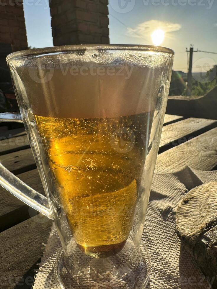 Refreshing beverage under the warm sunset glow in a tranquil setting photo
