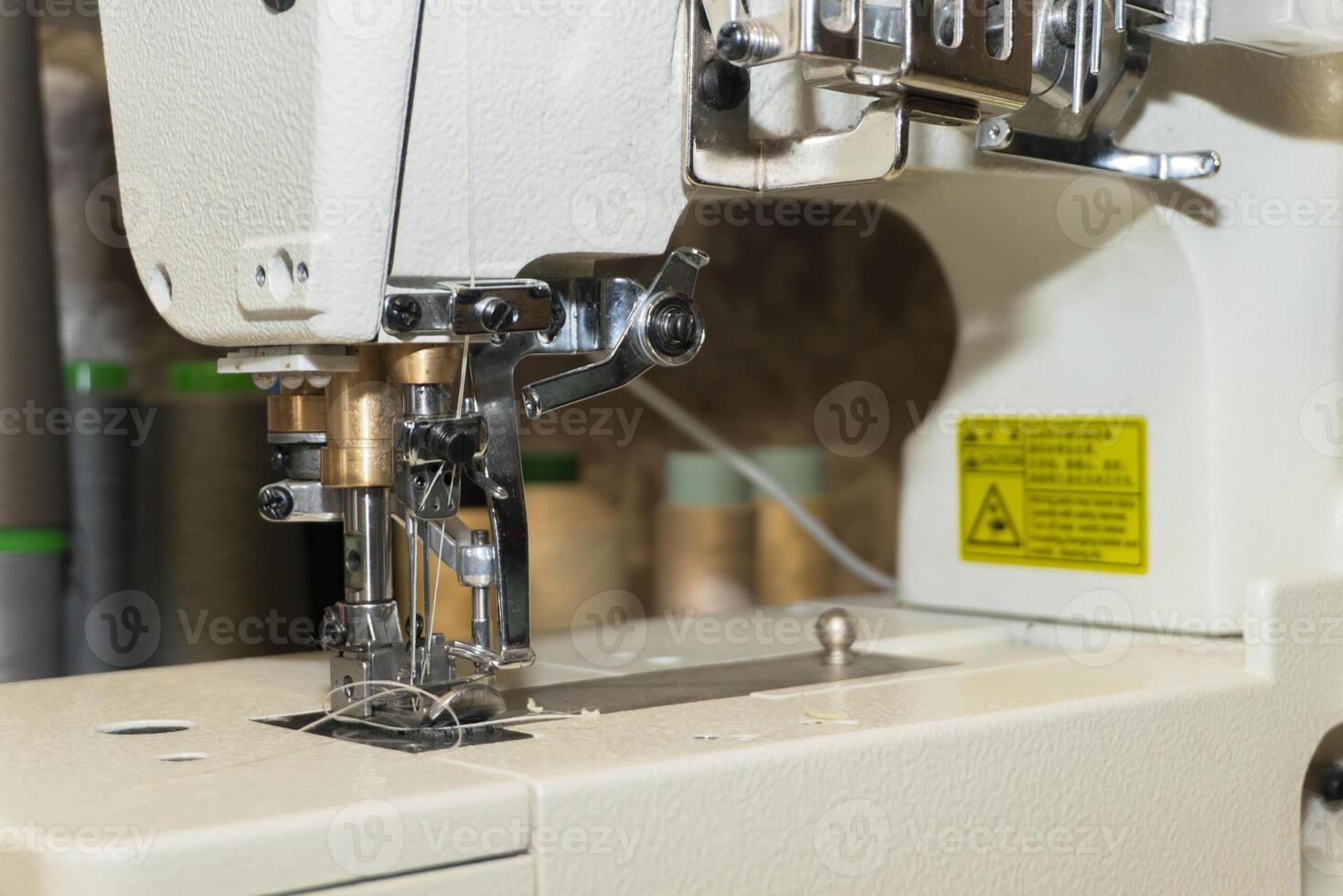 Close-up view of sewing machine with thread in workshop setting photo