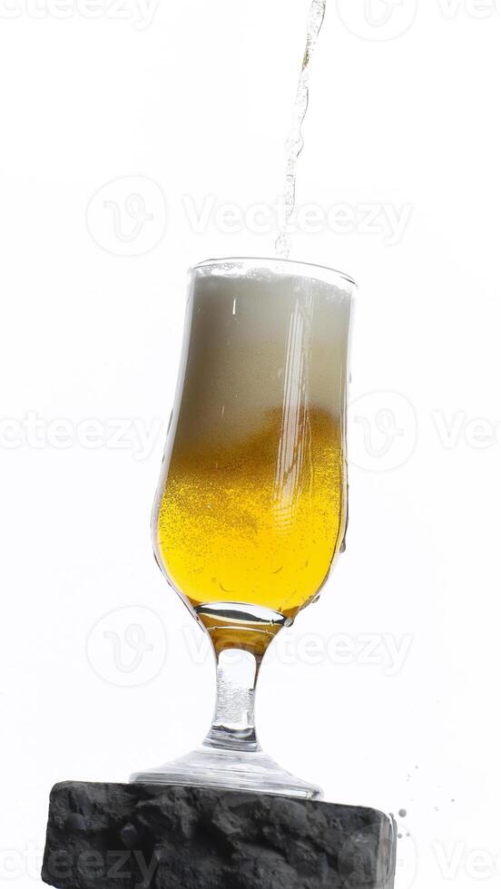 Refreshing golden beer poured into a tall glass with frothy head photo